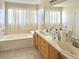 Bright bathroom featuring a large tub and double sink vanity with marble countertops at 66 John Stuart Mill St, Henderson, NV 89002