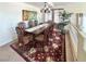 A cozy dining room with a wooden table, decorative rug, and natural light from the nearby windows at 66 John Stuart Mill St, Henderson, NV 89002