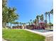 Community playground featuring colorful play structures, tall palm trees, and well-maintained grassy areas at 66 John Stuart Mill St, Henderson, NV 89002