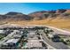Scenic aerial view showcases a home's beautiful backyard pool amidst a desert landscape and mountain backdrop at 6832 Apogee Ridge Ct, Las Vegas, NV 89135