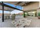Outdoor kitchen with BBQ, bar seating, and lush landscaping overlooking the luxurious pool and spa at 6832 Apogee Ridge Ct, Las Vegas, NV 89135