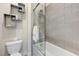 Clean bathroom with a toilet and shower-tub combo featuring decorative shelves and modern fixtures at 6832 Apogee Ridge Ct, Las Vegas, NV 89135
