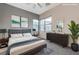 Bright, staged bedroom with a king bed, stylish decor, and modern furniture to create a relaxing atmosphere at 6832 Apogee Ridge Ct, Las Vegas, NV 89135