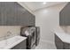 Functional laundry room equipped with modern washer and dryer, ample cabinets, and a sink at 6832 Apogee Ridge Ct, Las Vegas, NV 89135