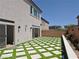 Landscaped backyard with artificial turf, a modern patio design, and block wall surround at 6837 Crimson Lily St, Las Vegas, NV 89139