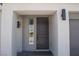 Close up of a modern front door with sidelight and contemporary exterior lighting at 6837 Crimson Lily St, Las Vegas, NV 89139