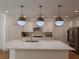 Gourmet kitchen featuring a large island, custom cabinets, stainless appliances and designer lighting at 6837 Crimson Lily St, Las Vegas, NV 89139