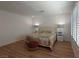 Spacious main bedroom featuring wood floors, shutters, and a comfortable ottoman at 6837 Crimson Lily St, Las Vegas, NV 89139