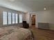 Large main bedroom with wood-style flooring, large windows, and a comfortable reading chair at 6837 Crimson Lily St, Las Vegas, NV 89139