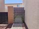 Side yard with modern lattice gate leading to the backyard, plus desert landscaping at 6837 Crimson Lily St, Las Vegas, NV 89139