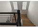 Bright staircase with wood steps, modern railings, and natural light from windows above, connecting floors at 6837 Crimson Lily St, Las Vegas, NV 89139