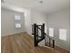 A staircase features wood floors, modern railings, and is illuminated by natural light from multiple windows at 6837 Crimson Lily St, Las Vegas, NV 89139