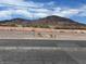 Wide view of the lot against a mountain range on a bright, sunny day at 693 W Pacific Ave, Henderson, NV 89002