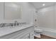 Bright bathroom with a white vanity and marbled top, white tiled walls, and wood-look flooring at 7604 Charles Conrad Cir, Las Vegas, NV 89145