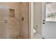 Modern bathroom with a tiled shower, toilet, and back door leading to the exterior, combining style and convenience at 7604 Charles Conrad Cir, Las Vegas, NV 89145