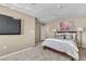 Cozy bedroom featuring plush carpeting, soft lighting, a wall-mounted TV, and tasteful floral artwork at 7604 Charles Conrad Cir, Las Vegas, NV 89145