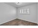 Bright bedroom featuring wood-look floors and a window with white shutters at 7604 Charles Conrad Cir, Las Vegas, NV 89145