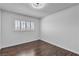 Bright bedroom featuring wood-look floors and a window with white shutters at 7604 Charles Conrad Cir, Las Vegas, NV 89145