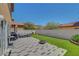 A backyard with faux grass, a tiled patio, outdoor furniture, a fire pit and a white fence at 8022 Severn Valley St, Las Vegas, NV 89139