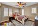Comfortable bedroom featuring wood floors, ceiling fan and bright windows that enhance the cozy ambiance at 8022 Severn Valley St, Las Vegas, NV 89139