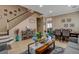 Combination of living and dining rooms featuring tile floors, a staircase, and comfortable seating arrangement at 8022 Severn Valley St, Las Vegas, NV 89139