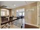 Hallway with stylish railing and hardwood floors that lead to another room featuring lots of natural light at 8022 Severn Valley St, Las Vegas, NV 89139