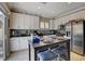 Charming kitchen featuring white cabinets, tiled backsplash, and a kitchen island with seating at 8022 Severn Valley St, Las Vegas, NV 89139
