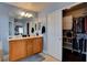 Well-lit main bathroom with double sinks, wood cabinets, a large mirror, and a walk-in closet at 8022 Severn Valley St, Las Vegas, NV 89139