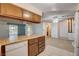 Open kitchen with wood cabinets, tile flooring, and white appliances offering lots of counter space at 804 S Mallard St, Las Vegas, NV 89107