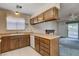 Functional kitchen with wood cabinets and drawers, dishwasher, and view to fireplace through the sliding door at 804 S Mallard St, Las Vegas, NV 89107