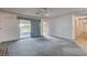 Bright and airy living room with sliding glass doors, neutral walls, carpet, and tile flooring at 804 S Mallard St, Las Vegas, NV 89107
