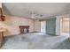 Living room with brick fireplace, sliding glass doors, neutral walls, carpet, and tile flooring at 804 S Mallard St, Las Vegas, NV 89107