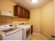 Well-equipped laundry room with side-by-side washer and dryer, shelving, and tile floors at 8321 Gorsky Ave, Las Vegas, NV 89131
