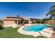 Resort-style backyard with a pool, covered patio and lush greenery for outdoor enjoyment at 8404 Dripping Rock Ct, Las Vegas, NV 89131