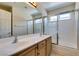 Double sink bathroom vanity, a wide mirror, and tub with sliding doors at 8404 Dripping Rock Ct, Las Vegas, NV 89131
