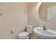 Half bathroom with toilet and sink, along with beige walls and white appliances at 8404 Dripping Rock Ct, Las Vegas, NV 89131