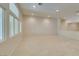 Bright, expansive living room featuring neutral carpets, recessed lights, and large windows at 8404 Dripping Rock Ct, Las Vegas, NV 89131