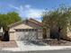Well-maintained single-story home with a two-car garage, desert landscaping, and a mature tree at 8616 Hidden Pines Ave, Las Vegas, NV 89143