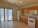 Practical kitchen featuring neutral countertops, wood cabinets, tile floors, and sliding glass door at 8616 Hidden Pines Ave, Las Vegas, NV 89143