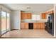 Well-lit kitchen featuring light wood cabinets, black appliances and sliding door access to backyard at 8626 Anderson Dale Ave, Las Vegas, NV 89178