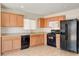 Well-equipped kitchen with light wood cabinets and black appliances at 8626 Anderson Dale Ave, Las Vegas, NV 89178