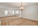 Spacious living room with neutral carpet, chandelier, ceiling fan, and plenty of natural light at 8626 Anderson Dale Ave, Las Vegas, NV 89178
