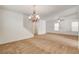 Spacious carpeted living room featuring staircase, ceiling fan, and abundant natural light at 8626 Anderson Dale Ave, Las Vegas, NV 89178