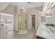 Bright bathroom featuring a glass enclosed shower, double sinks, and view to an adjacent bedroom at 904 Rhyolite Ter, Henderson, NV 89011