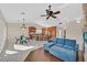Bright open-concept living room with modern kitchen, dining area, tile flooring, and comfortable blue sofa at 904 Rhyolite Ter, Henderson, NV 89011