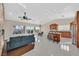 Bright open-concept living room with modern kitchen, dining area, tile flooring, and comfortable blue sofa at 904 Rhyolite Ter, Henderson, NV 89011