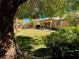 Lush backyard featuring a manicured lawn, mature trees, and views of the home's rear elevation at 9812 Turtle Walk Ave, Las Vegas, NV 89149
