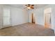 Bright primary bedroom with carpet flooring, ceiling fan, and an ensuite bathroom that offers a relaxing retreat at 9812 Turtle Walk Ave, Las Vegas, NV 89149