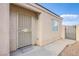 Close up of front door with security screen, tan stucco, small window, and gravel landscaping at , Las Vegas, NV 89130
