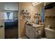 Bathroom with a single sink vanity, a mirror, and floating shelves at 10049 Fragile Fields St, Las Vegas, NV 89183